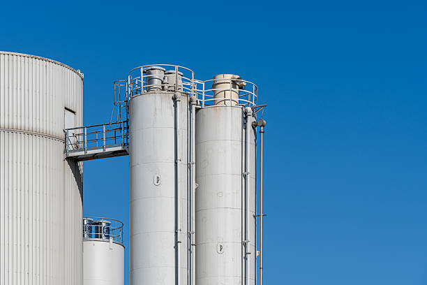 Germany, Berlin, Neukoelln, August 26, 2025 - White industrial silos against the blue sky