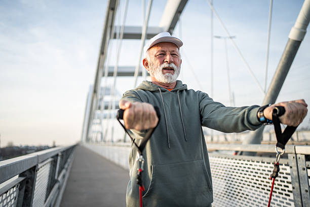 istock Senior man exercising with resistance bands on a bridge 2232325021