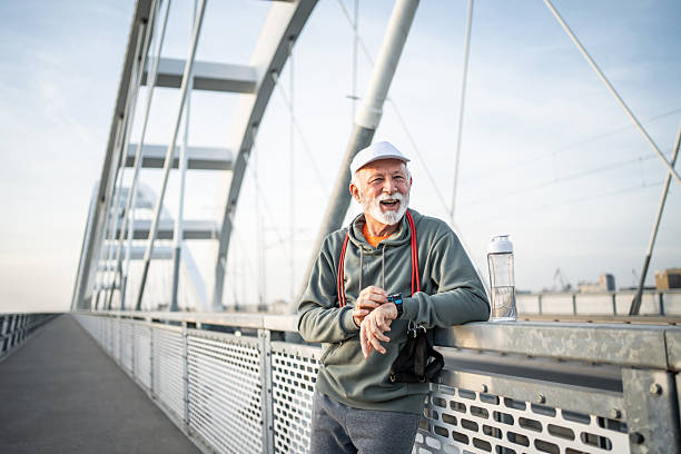 istock Senior man checking smartwatch after exercising on bridge 2232326422