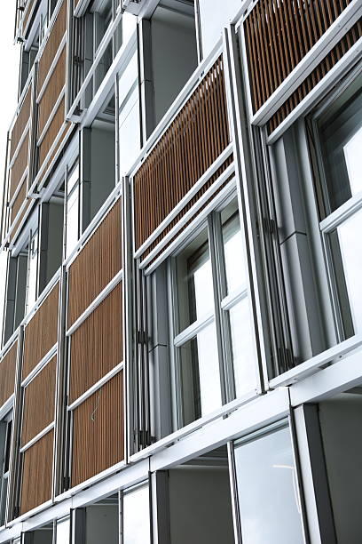 istock Modern apartment building exterior; sleek silver frames, wood slatted balconies. 2232327240