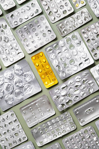 istock Empty blister packs and one yellow blister pack on green background. 2232327895