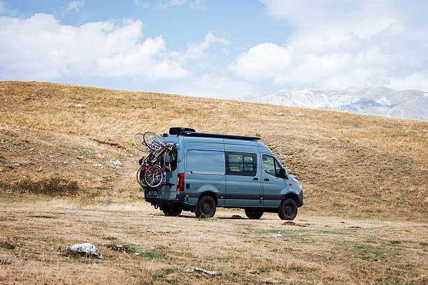 istock Camper van with bicycles on a grassy field. 2232328381