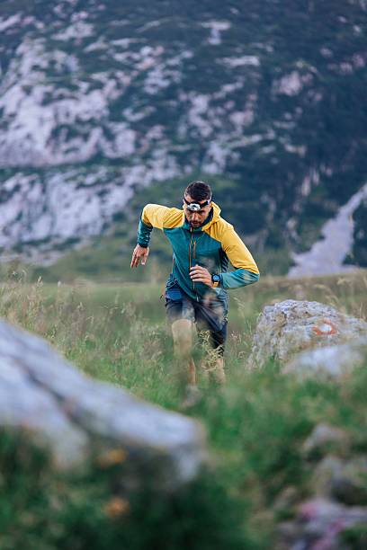 istock Trail runner in colorful jacket on rocky terrain. 2232328383
