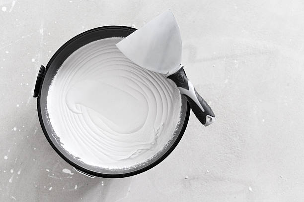 istock White plaster bucket and metal spatula on gray surface for construction renovation or interior wall finishing concept 2232328719