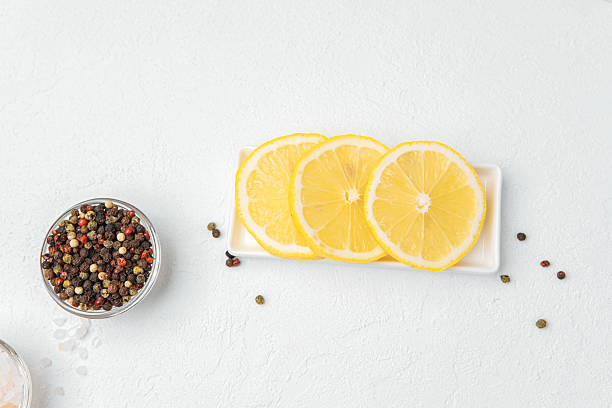 istock Lemon slices with pepper  on white background 2232329106