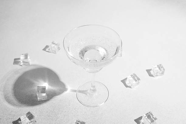 istock Glass drink with ice cubes and shadows on bright surface, clear liquid refreshment, bubbly beverage. 2232329756