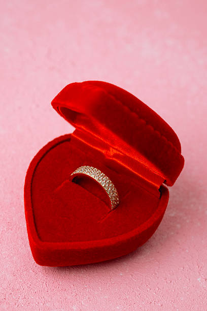 istock Paved diamond ring in heart-shaped red box on pink background 2232330044