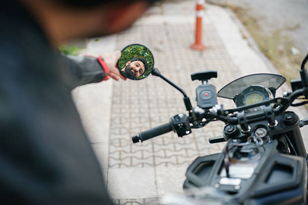 istock Close-up of a man’s face reflected in the motorcycle mirror while adjusting it. 2232332187