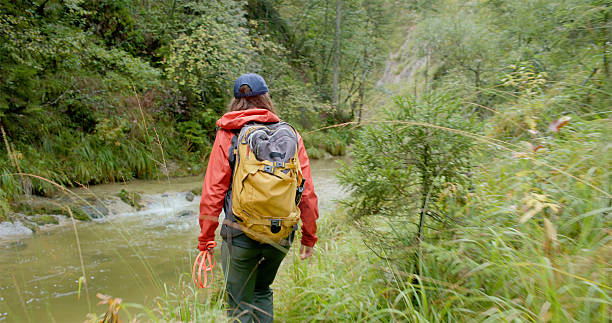 istock Young Caucasian Female Hiking by Forest River 2232332826