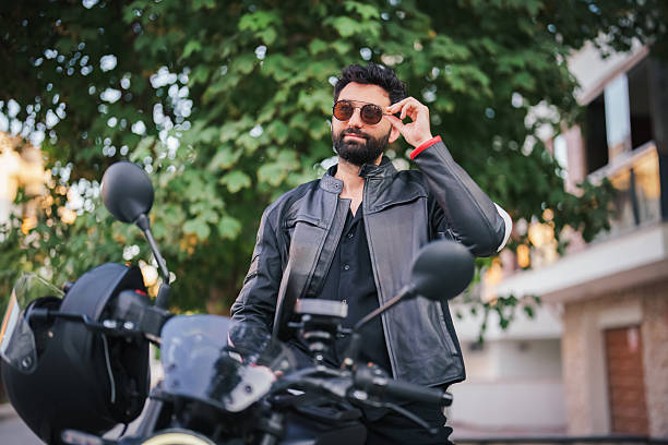 istock Man putting on sunglasses next to motorcycle 2232332942