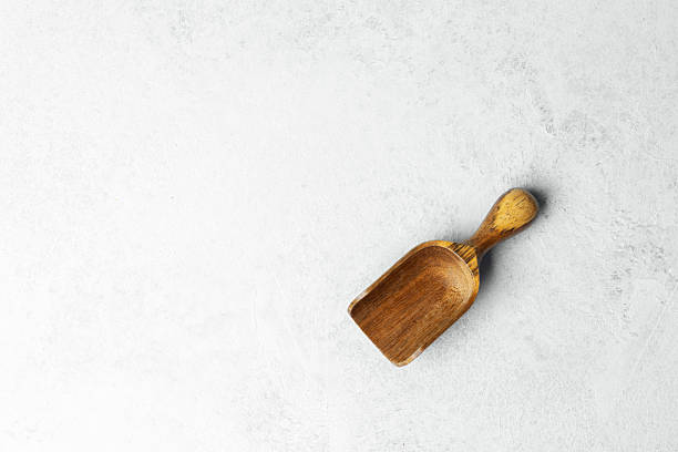 istock Wooden scoop resting on a light textured surface in a minimalist setting 2232335060