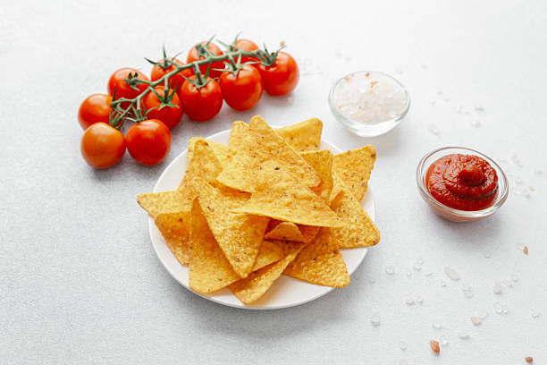 istock Crispy nachos with tomatoes, salsa and salt on white background 2232335153