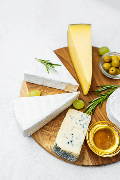 istock Cheese platter with assorted cheeses and olives on wooden board display 2232335195