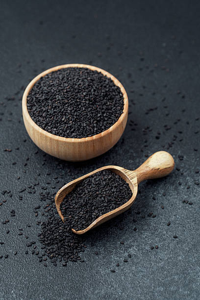 istock Black sesame seeds in bowl and scoop on dark background 2232335485