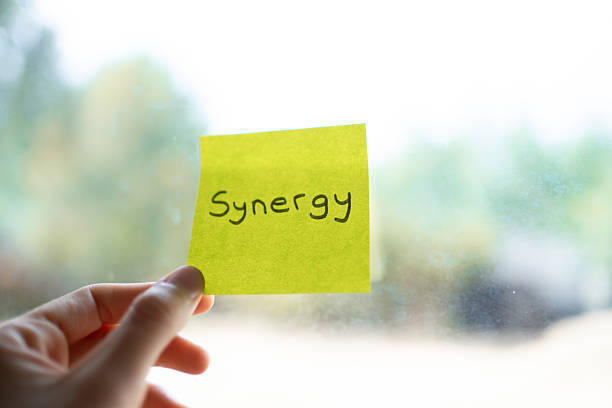 istock Hand holding adhesive note with synergy written on it 2232336558