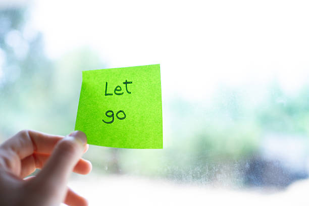 istock Hand holding adhesive note with let go written on it 2232336604