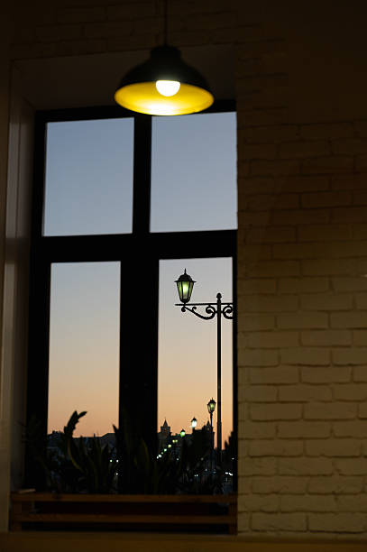 Enjoying a cozy view through a window with a glowing street lamp, adding warmth and ambiance