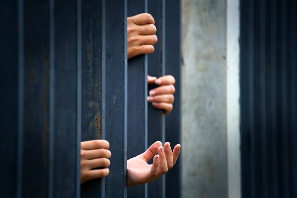 istock Hands Reaching Through Bars Symbolizing Hope and Despair in Captivity 2232339343