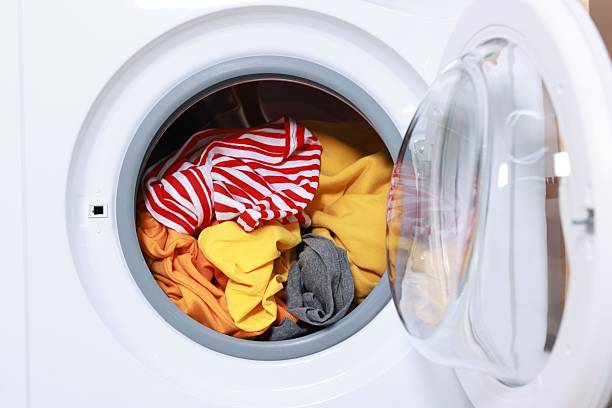 istock Modern washing machine with clothes in drum, closeup 2232343235