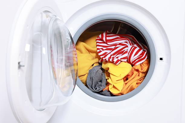 istock Modern washing machine with clothes in drum, closeup 2232343243