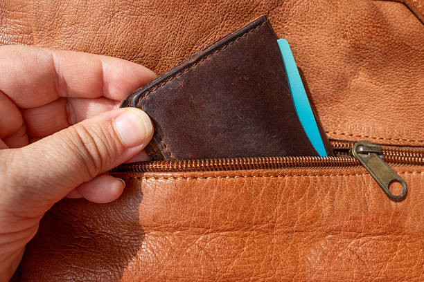 istock Hand thief pulling wallet from bag pocket, pickpocketing scene, Pickpocket stealing wallet, danger during vacation, security issue, travel risks, theft during travel 2232343428