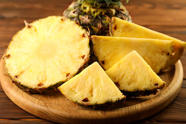 istock Cut fresh ripe pineapple on wooden table, closeup 2232343876