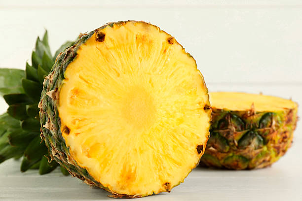 istock Cut fresh ripe pineapple on white wooden table, closeup 2232343879