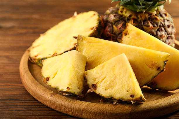 istock Cut fresh ripe pineapple on wooden table, closeup 2232343946