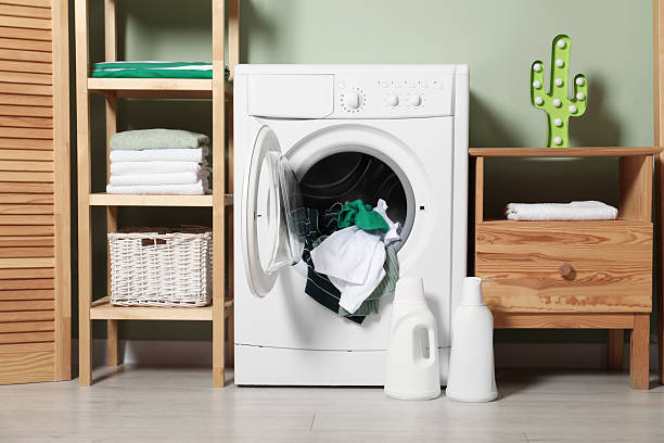istock Washing machine, detergents and towels in room 2232347012