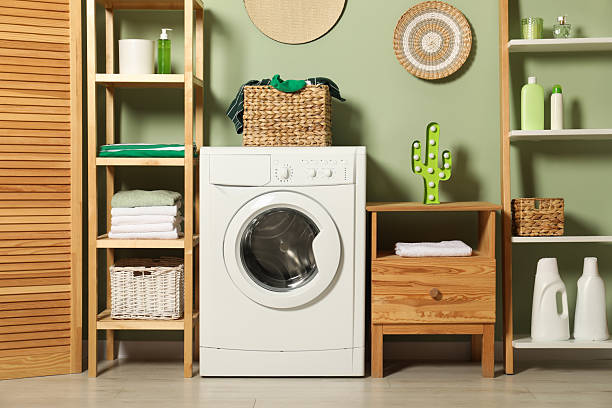 istock Washing machine, detergents and basket with laundry in room 2232347040