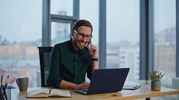 istock Friendly consultant calling smartphone entering laptop at workplace closeup. 2232348534