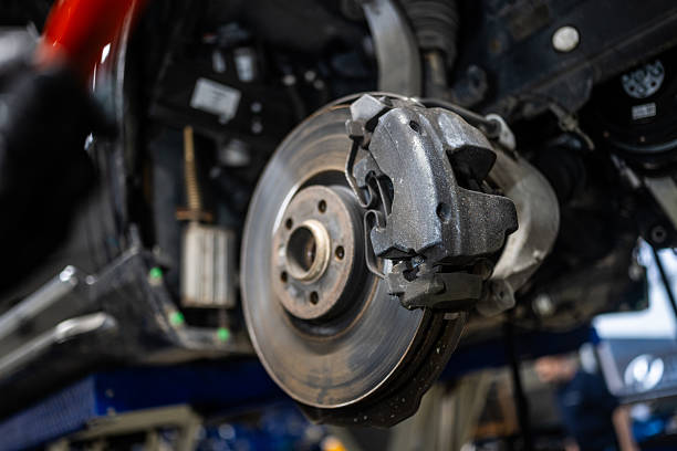 istock Car Brake Disc and Caliper in Repair Shop Setting 2232348971