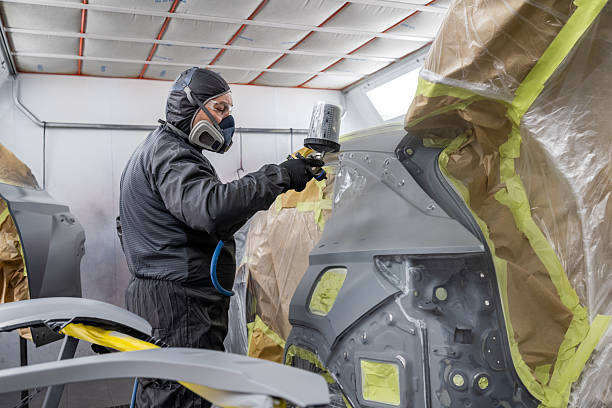 istock Automotive Painter Applying Spray Coat to Car Panel in Workshop 2232348990