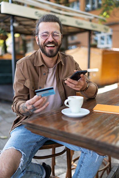 istock Happy man making online payment using credit card and smartphone 2232350519