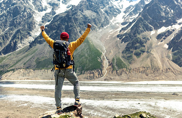 istock Triumphant Hiker Standing on a Mountain Overlooking a Stunning Snowy Valley 2232353257