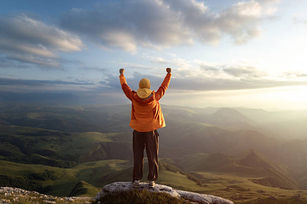Triumphant Hiker Celebrating Sunrise on a Scenic Mountain Peak