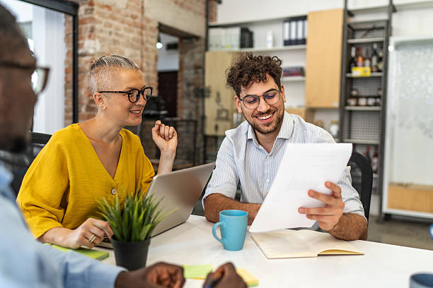 istock Smiling business team analyzing documents during meeting in modern office 2232355116