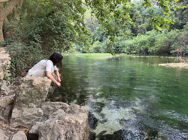 Woman about to dip her feet into the cold water