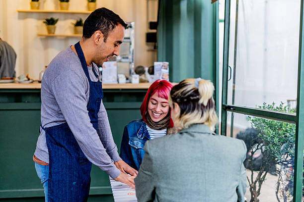 istock Waiter serving customers in a coffee shop 2232355823