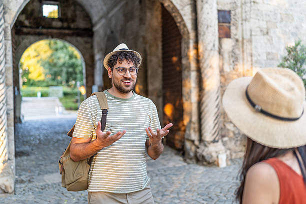 istock Tourist guide explaining history to a traveler under ancient arch 2232355942