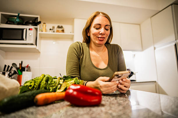 istock Mature woman using mobile phone at home 2232356889