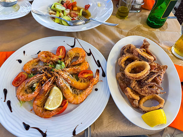 Delicious fried giant squid rings and shrimps on plate in tavern.