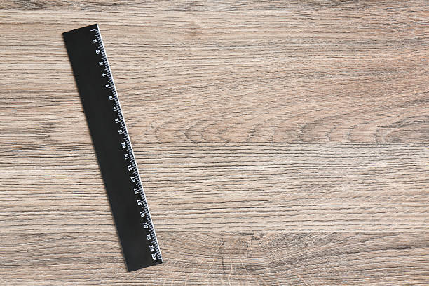 istock One black ruler on wooden table, top view. Space for text 2232357378