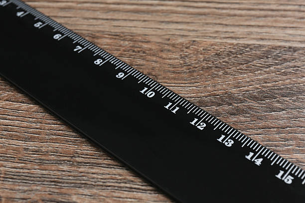 istock One black ruler on wooden table, closeup 2232357393