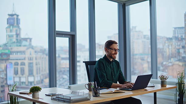istock Office specialist satisfied online project at modern workplace. Smiling man 2232358249