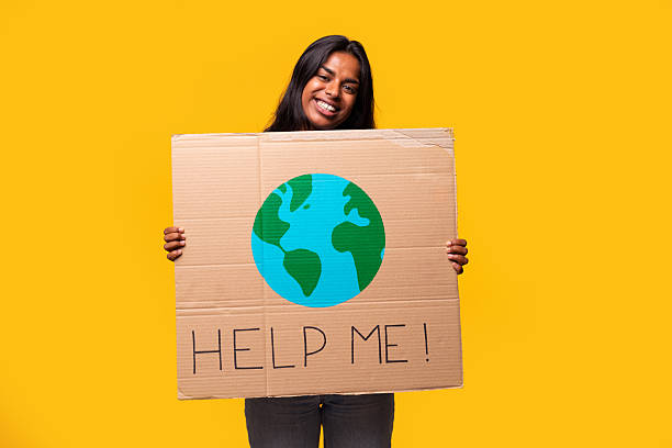 istock Young woman holding sign with earth drawing and help me text 2232359377