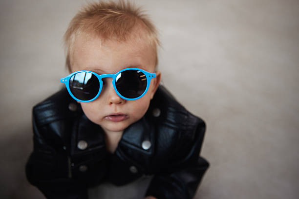 A stylish portrait of a baby rocking a leather jacket and sunglasses, exuding attitude and charm. A playful and fashionable take on early personality and confidence.