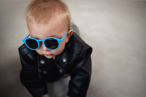 A stylish portrait of a baby rocking a leather jacket and sunglasses, exuding attitude and charm. A playful and fashionable take on early personality and confidence.