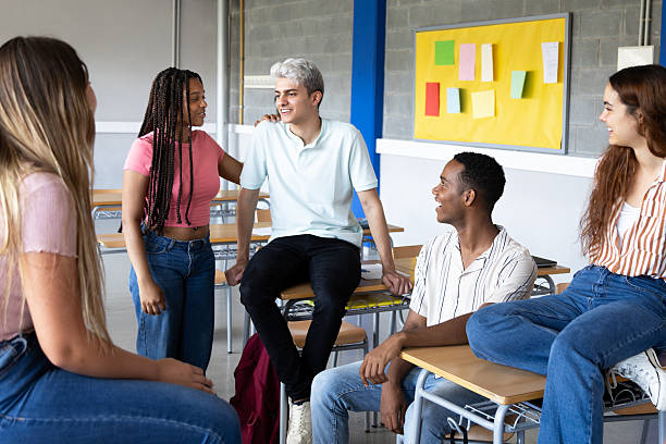 istock Cheerful students chatting together in classroom after school 2232360150