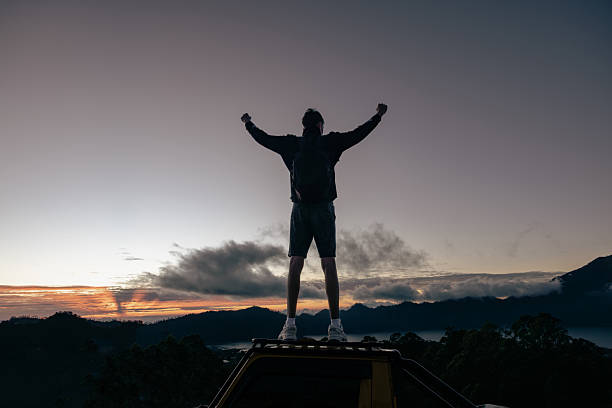 istock Happy Man With Raised Arms Gesture Triumph On Exposed Cliff. 2232361836